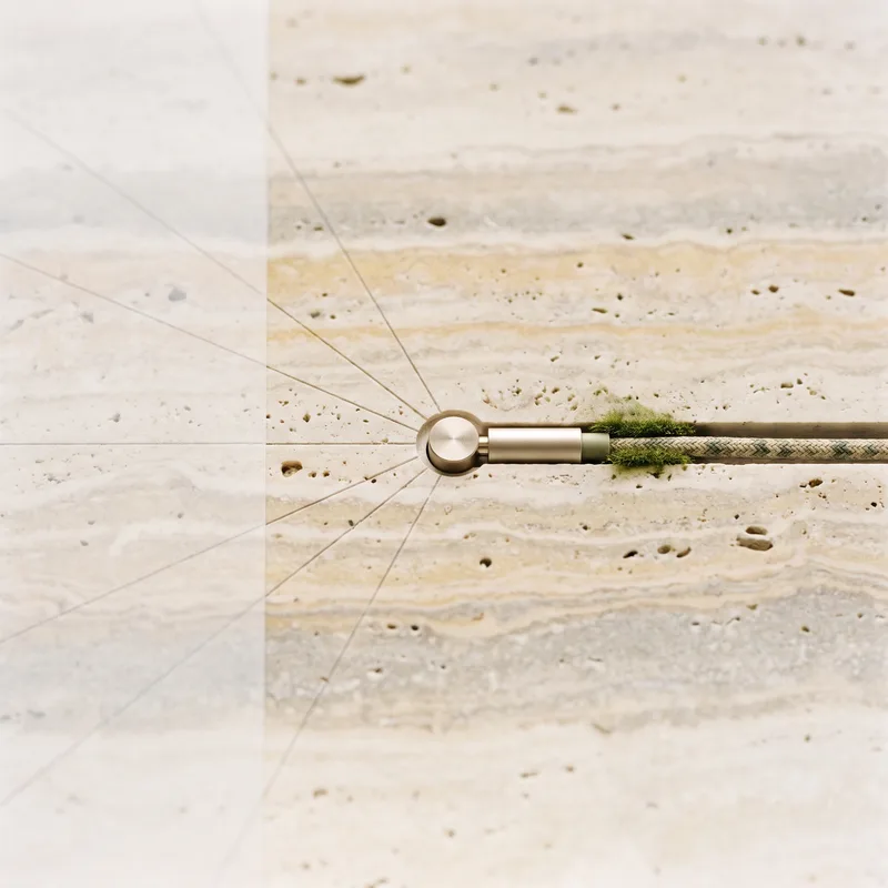 Travertine slab with finely scribed layout lines that meet in a champagne plug, a braided cable with moss leading out